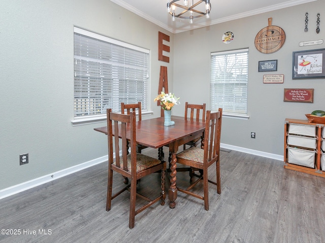 dining space with crown molding, wood-type flooring, and an inviting chandelier