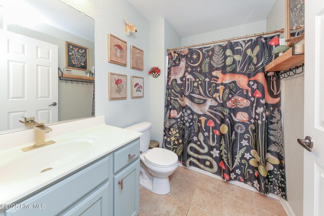 bathroom featuring tile patterned floors, toilet, and vanity