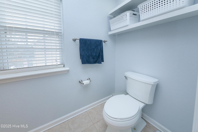 bathroom with toilet and tile patterned flooring