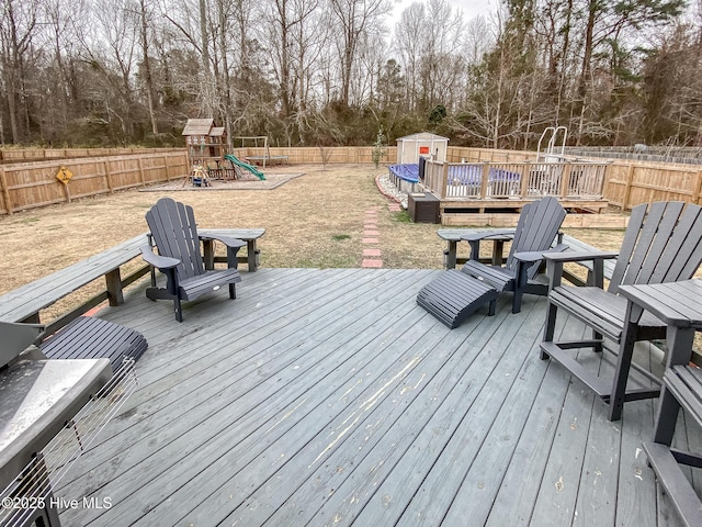 deck with a playground and a storage unit