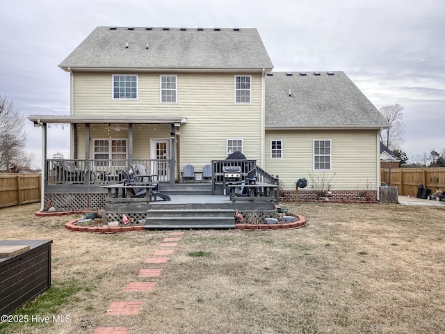 rear view of house featuring a deck and a lawn