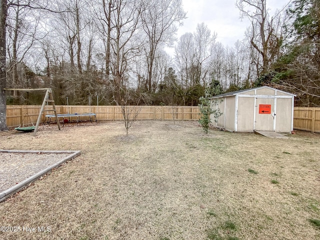 view of yard with a playground, a storage unit, and a trampoline