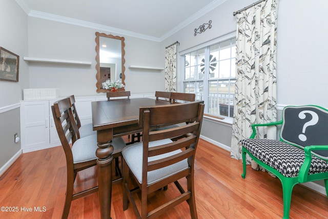 dining space with crown molding and light hardwood / wood-style flooring