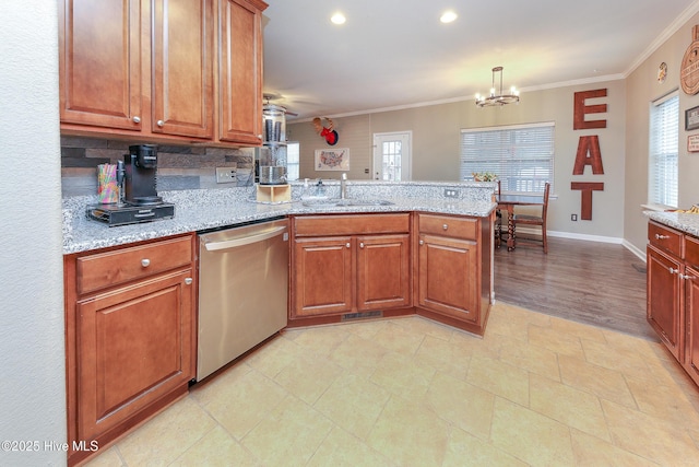 kitchen featuring light stone countertops, stainless steel dishwasher, sink, decorative light fixtures, and kitchen peninsula