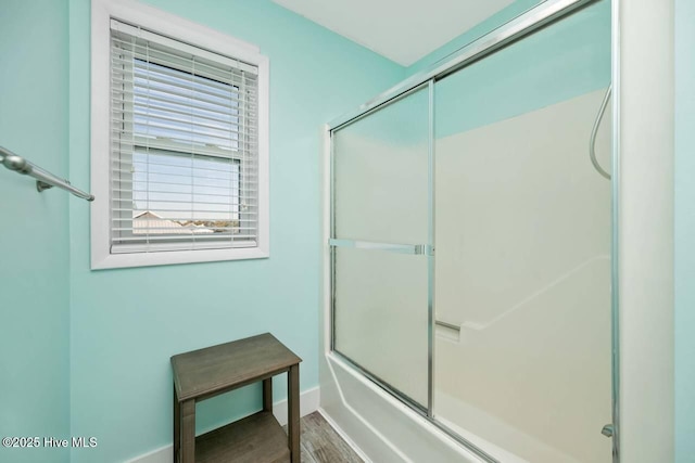 bathroom featuring wood-type flooring and enclosed tub / shower combo