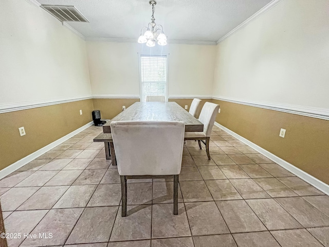 dining area with a textured ceiling, an inviting chandelier, crown molding, and light tile patterned flooring