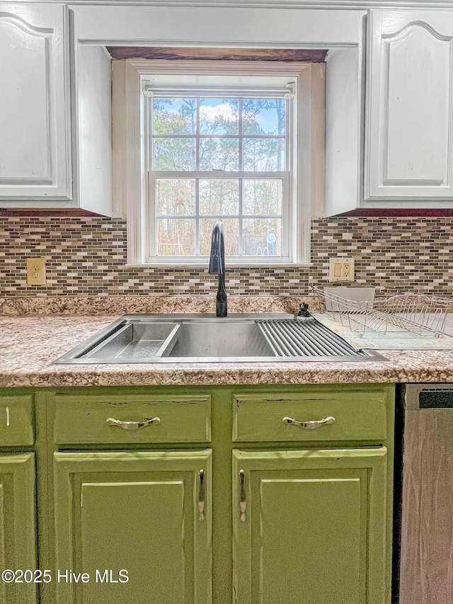 kitchen with white cabinetry, backsplash, and sink