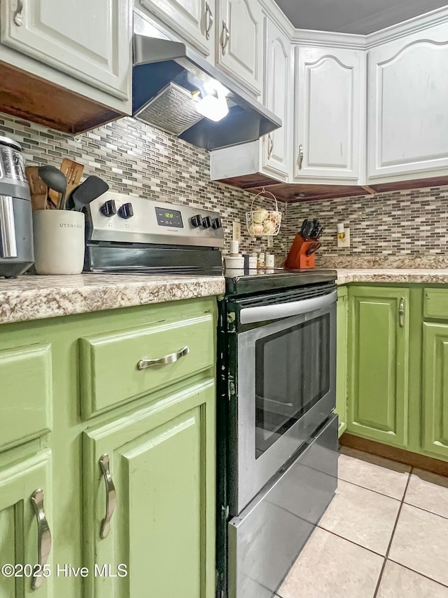 kitchen featuring stainless steel range with electric stovetop, light tile patterned floors, white cabinetry, and decorative backsplash