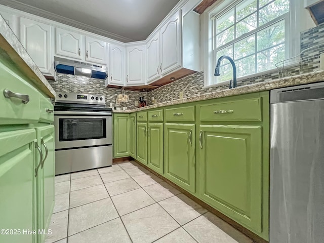 kitchen featuring light stone countertops, backsplash, appliances with stainless steel finishes, and white cabinetry