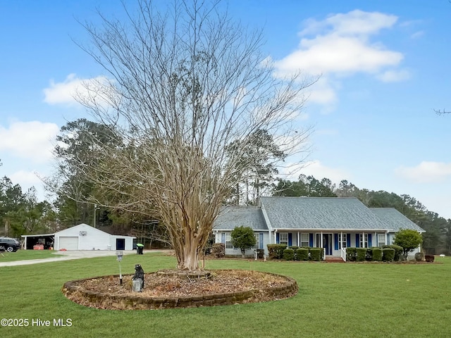 ranch-style home with a front yard, covered porch, a garage, and an outbuilding