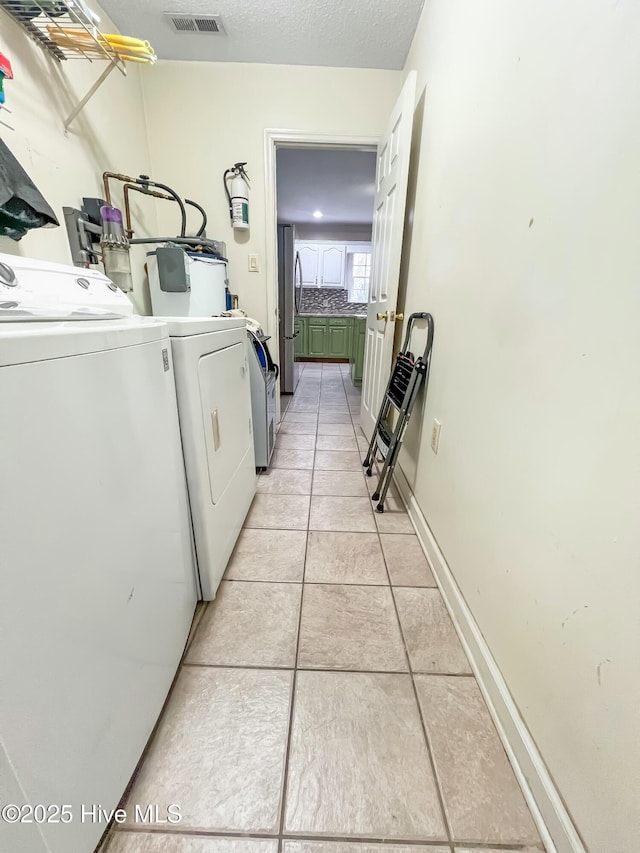 laundry room featuring light tile patterned floors and washer and dryer