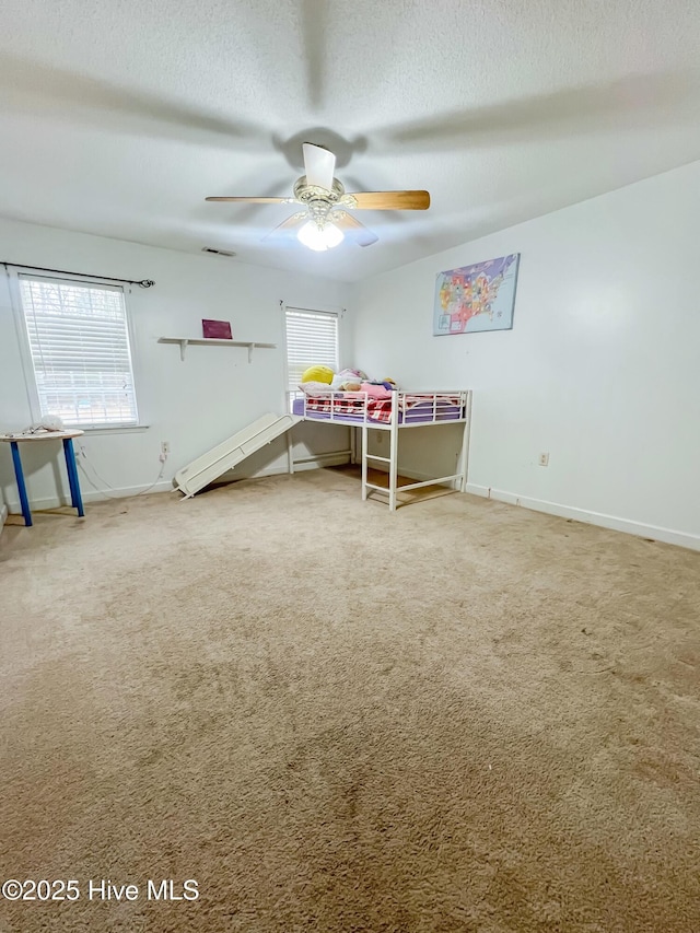 bedroom featuring a textured ceiling, ceiling fan, and carpet flooring