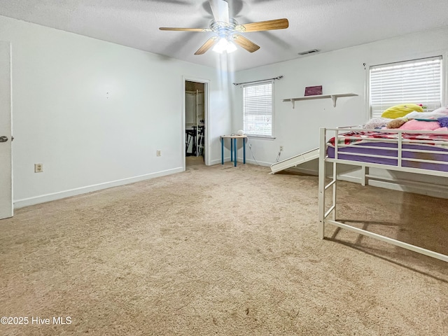 bedroom featuring ceiling fan, a textured ceiling, and carpet floors