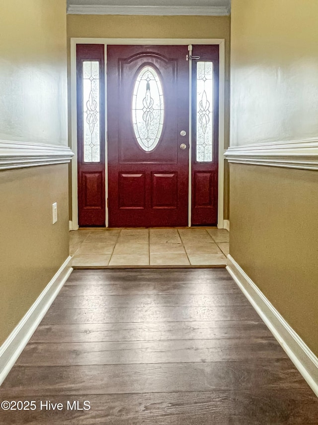 foyer featuring light wood-type flooring and ornamental molding