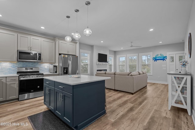 kitchen with light countertops, a wealth of natural light, appliances with stainless steel finishes, and a ceiling fan