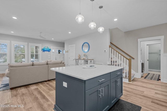 kitchen featuring a center island, light wood-style floors, ceiling fan, light countertops, and recessed lighting