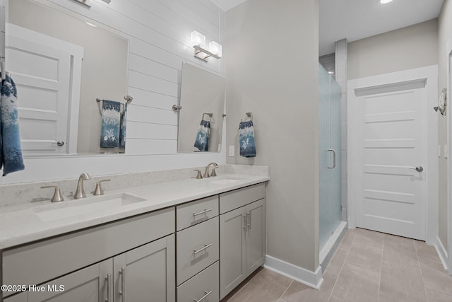 full bathroom featuring tile patterned floors, a sink, a shower stall, and double vanity