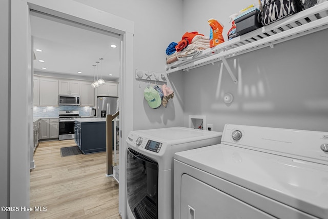 washroom with recessed lighting, light wood-style floors, washer and clothes dryer, and laundry area