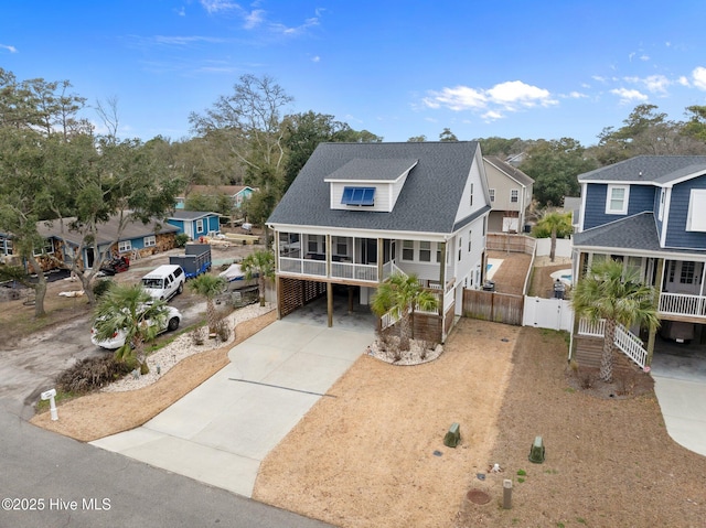 245 NE 64th St, Oak Island, NC 28465 - coastal inspired home featuring covered porch, driveway, a carport, roof with shingles, and a residential view