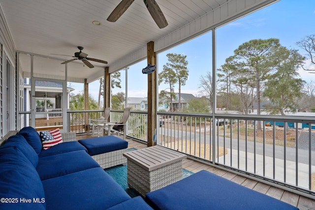 sunroom featuring ceiling fan, an outdoor hangout area, and a residential view