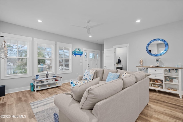 living area featuring light wood-type flooring, a ceiling fan, baseboards, and recessed lighting