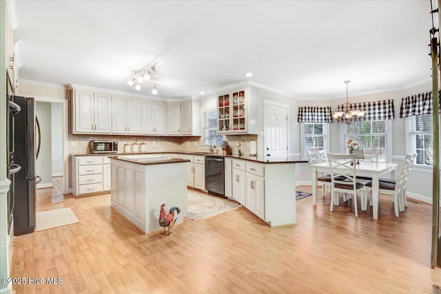 kitchen featuring hanging light fixtures, white cabinetry, stainless steel appliances, and a center island