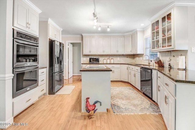 kitchen featuring stainless steel appliances, ornamental molding, and white cabinets