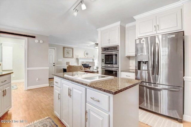 kitchen featuring white cabinetry, ceiling fan, stainless steel appliances, dark stone counters, and crown molding