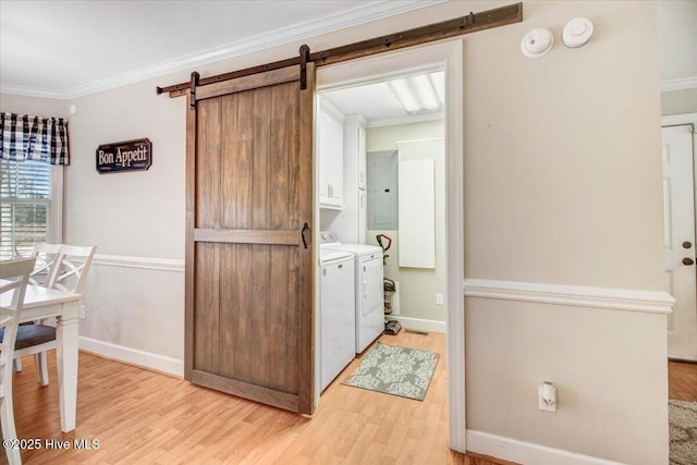 laundry room featuring cabinets, independent washer and dryer, ornamental molding, and a barn door