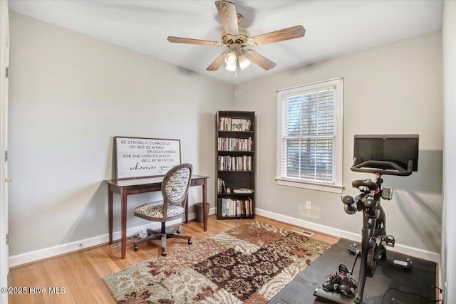 office with light wood-type flooring and ceiling fan