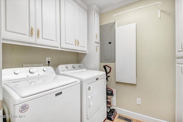 laundry room featuring washing machine and dryer, cabinets, electric panel, and ornamental molding