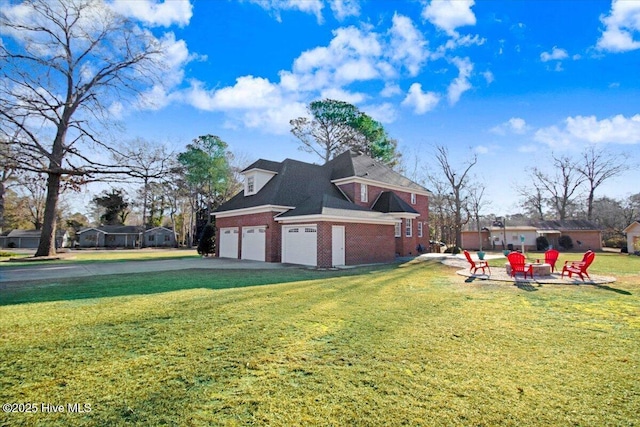 view of side of home with a garage, a yard, and a fire pit