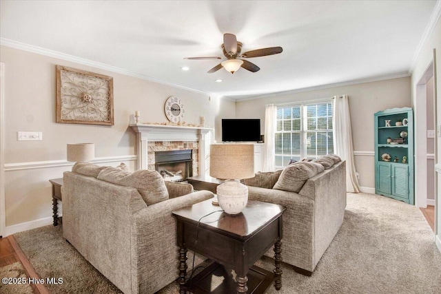 living room with ceiling fan, crown molding, a fireplace, and light colored carpet