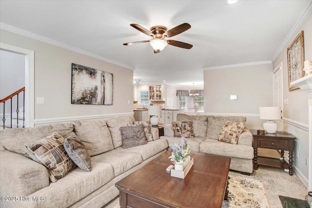 living room featuring ceiling fan, light colored carpet, and crown molding