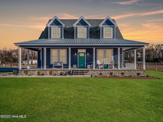 back house at dusk with a yard and covered porch