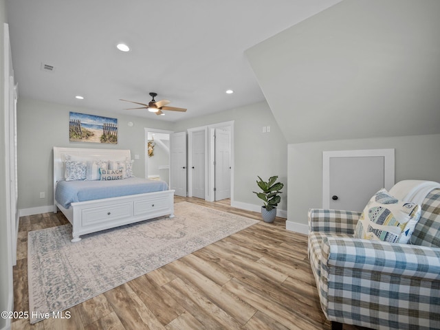 bedroom with ceiling fan, vaulted ceiling, and light wood-type flooring