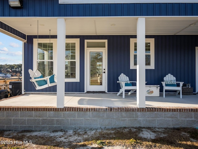 entrance to property featuring covered porch and central air condition unit