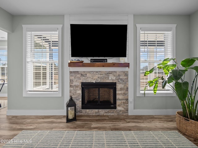 living room with a fireplace, plenty of natural light, and hardwood / wood-style floors