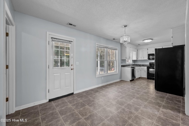 kitchen featuring sink, hanging light fixtures, black appliances, white cabinets, and a chandelier