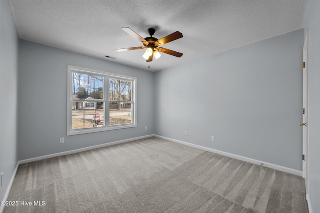 empty room featuring ceiling fan, carpet floors, and a textured ceiling