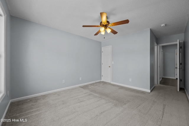 carpeted spare room with ceiling fan and a textured ceiling