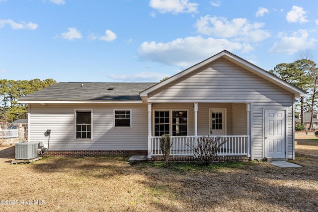 back of property with a yard, cooling unit, and covered porch