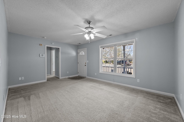 spare room with carpet, a textured ceiling, and ceiling fan