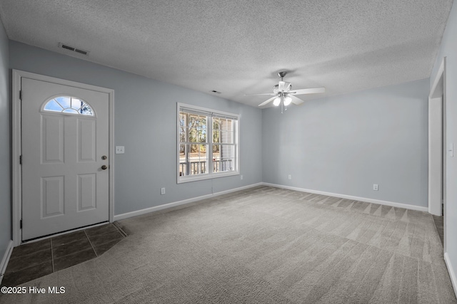 carpeted foyer with a textured ceiling and ceiling fan