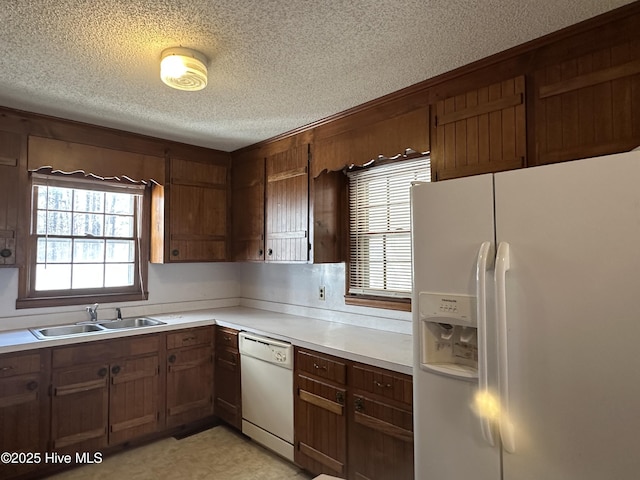 kitchen with sink, white appliances, and a textured ceiling