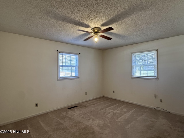 carpeted spare room with ceiling fan and a textured ceiling