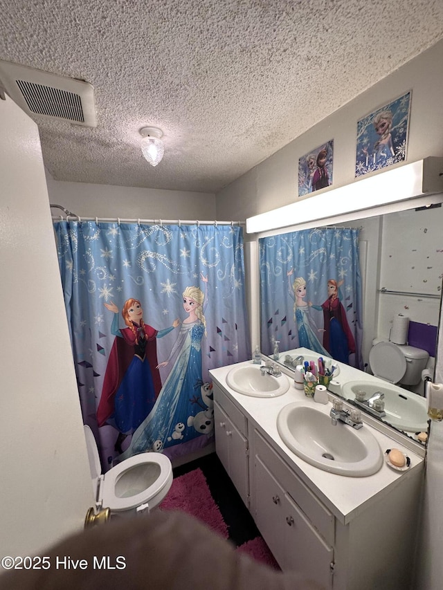 bathroom featuring a textured ceiling, toilet, vanity, and a shower with shower curtain