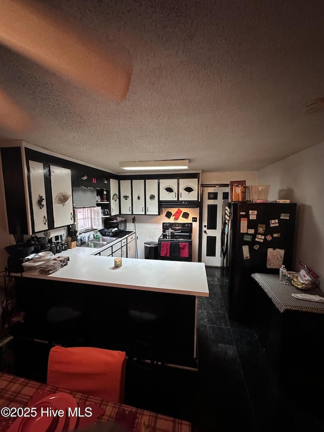 kitchen featuring white cabinets, a peninsula, black appliances, and a textured ceiling