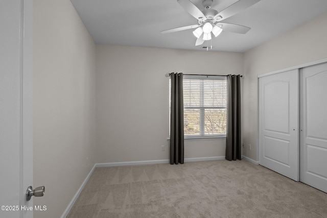 unfurnished bedroom with ceiling fan, light colored carpet, and a closet