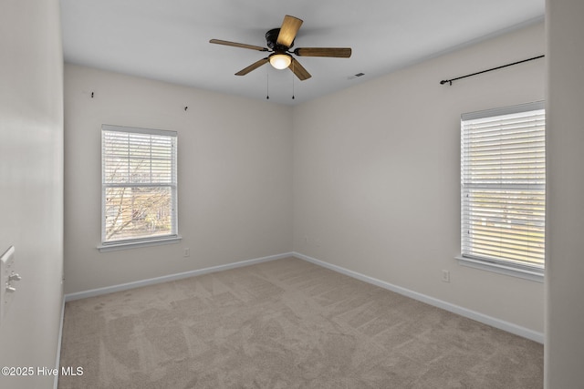 carpeted spare room featuring ceiling fan